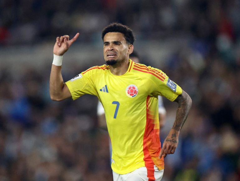 Luis Diaz raises his arm in celebration after scoring
