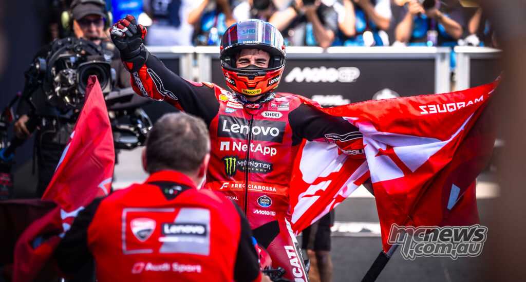 Marc Marquez celebrates with a red flag after his Hungarian MotoGP victory.