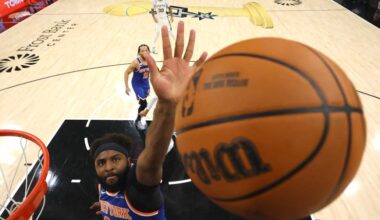 New York Knicks center Mitchell Robinson attempts to block a shot against the San Antonio Spurs during an NBA game.