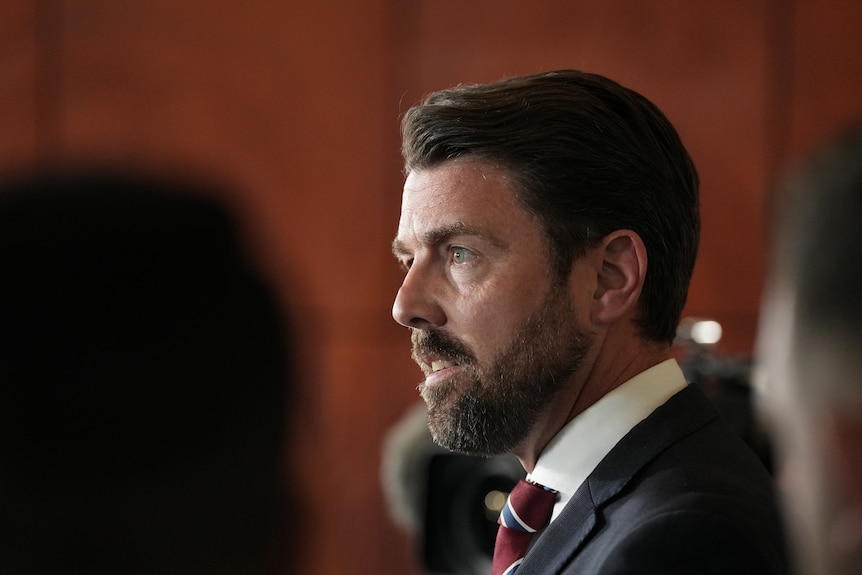 Side profile of Jonno Duniam in suit and tie.