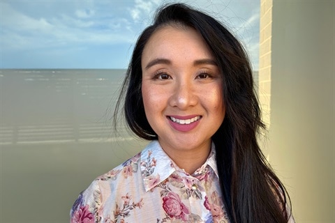 A woman smiles towards the camera