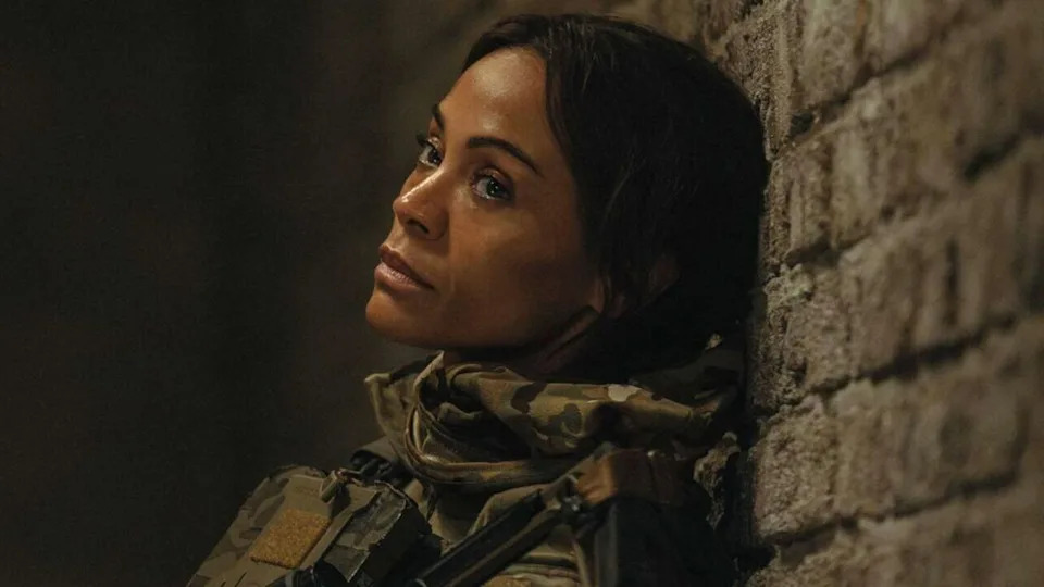 Zoe Saldana sits slumped against the wall.