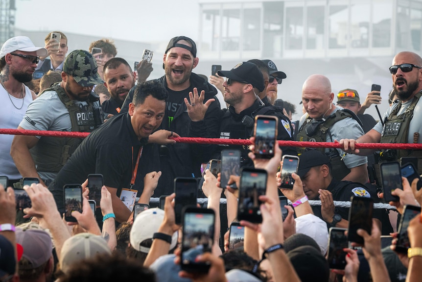 Sean Strickland is surrounded by security at a UFC fan event.