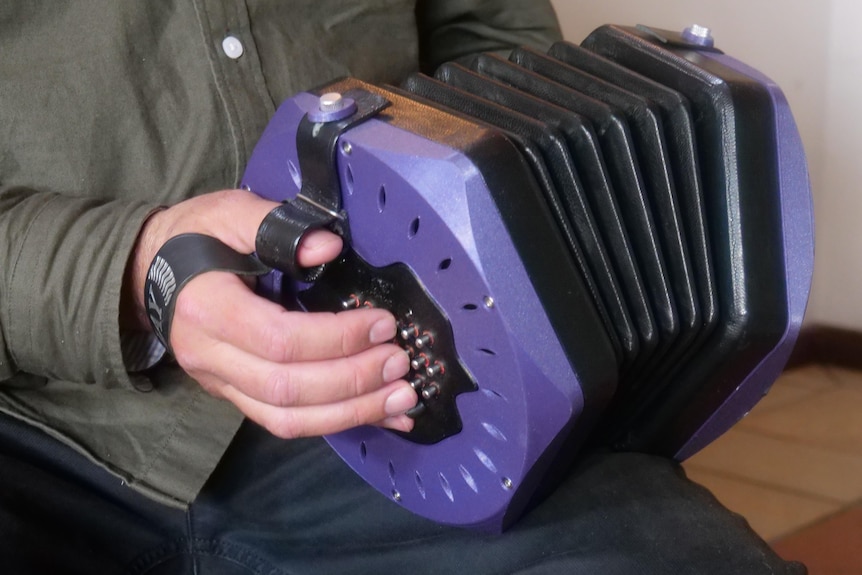 A close of hand holding a concertina