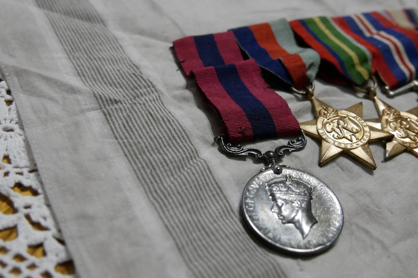 A red and blue stripped ribbon attached toa silver round medal.