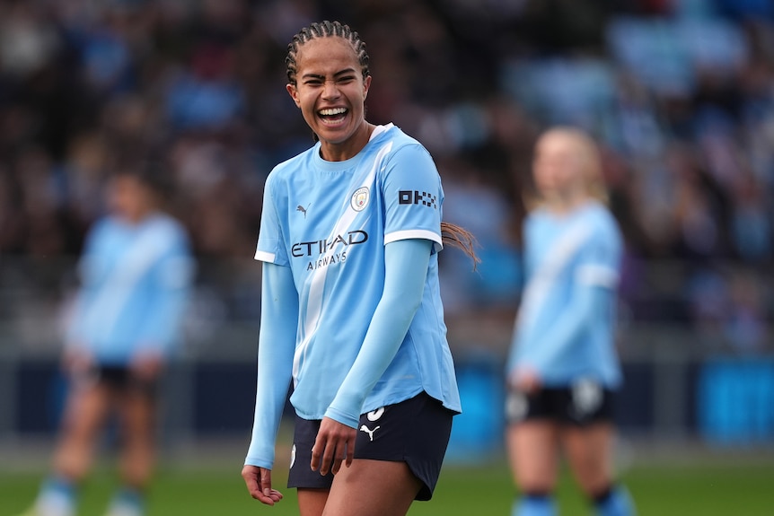 Mary Fowler smiles on the field during a Manchester City game