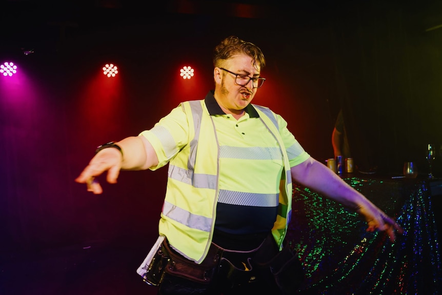 A drag king dressed in high vis.