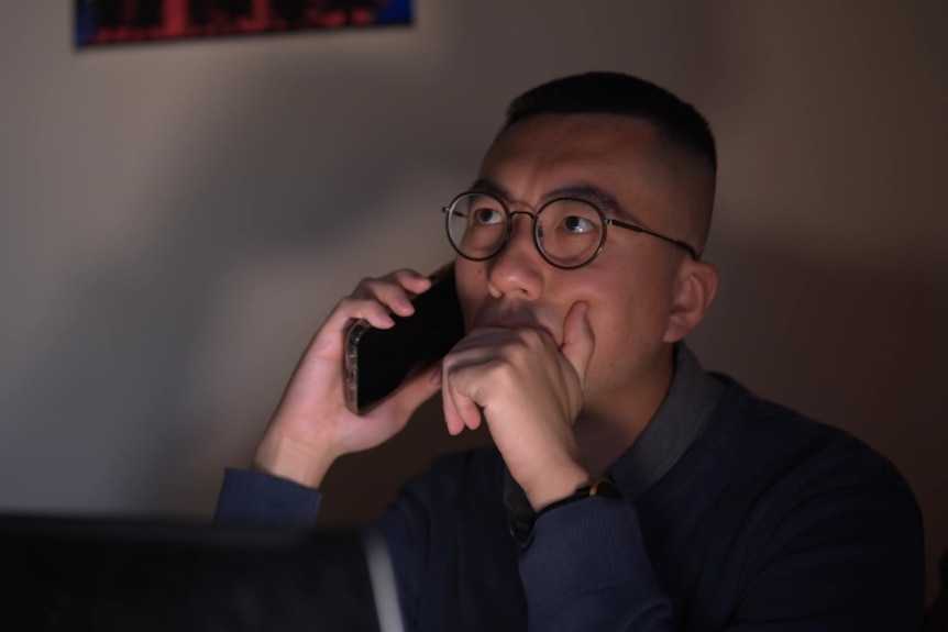 A man looks worried as he speaks to someone over the phone.