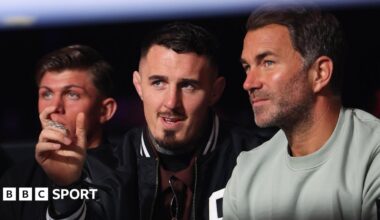 Eddie Hearn and Tom Aspinall talk while they watch a boxing match in April 2026