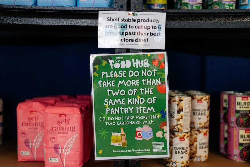 Flour, bean mix cans and signage on the shelf in a mini grocery store