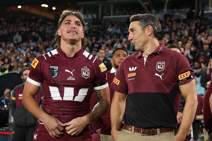 Billy Slater talks to Reece Walsh on the sideline during a State of Origin game.