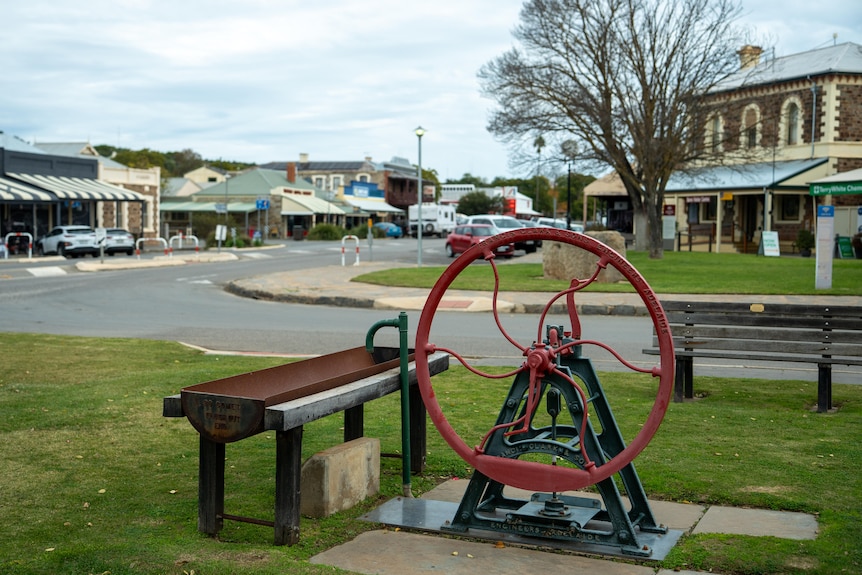 An old fashioned water pump located near an intersection in a country town.