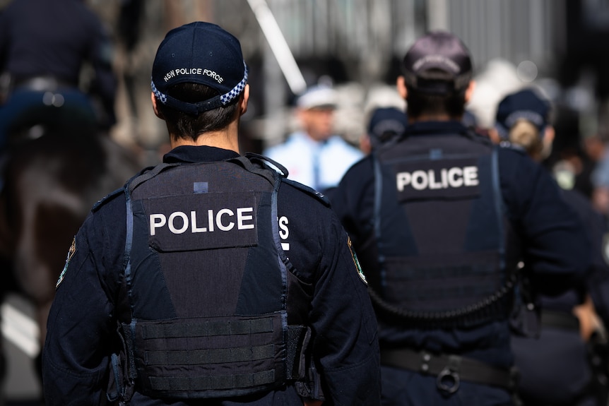 Uniformed Police officers survey a busy protest
