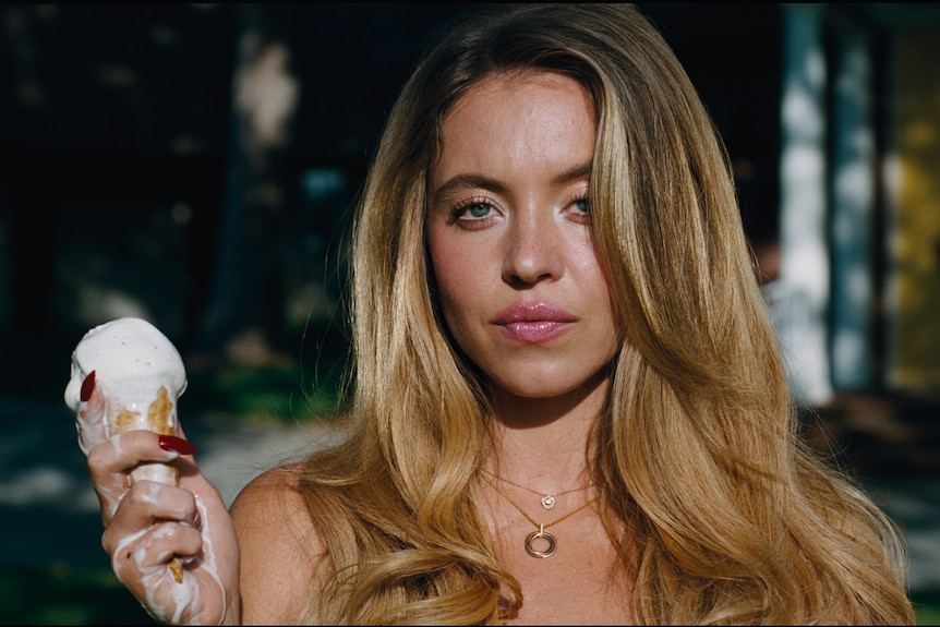 Sydney Sweeney holding an ice cream cone which is melting in her hand