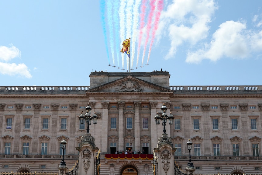Several jets fly over Buckingham Palace leaving smoke trails of blue, white and red 