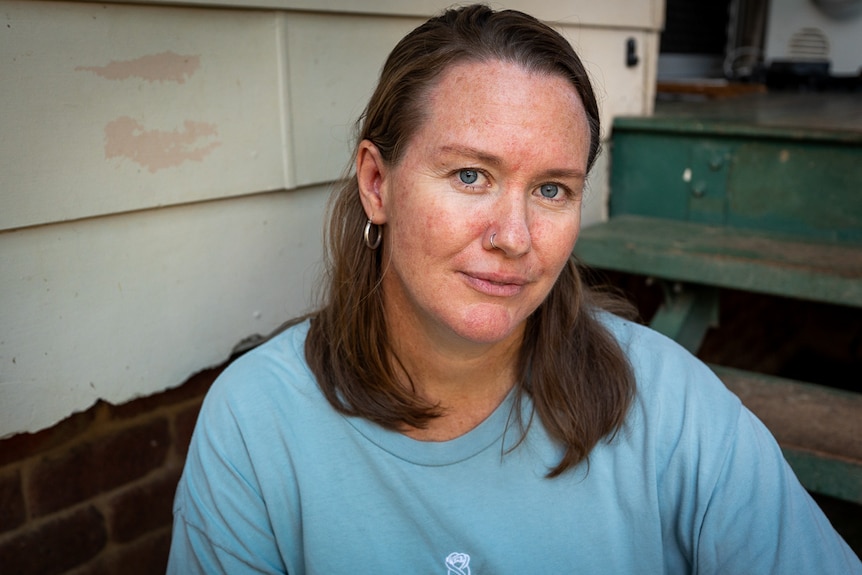 A close-up of a woman sitting on her front steps.