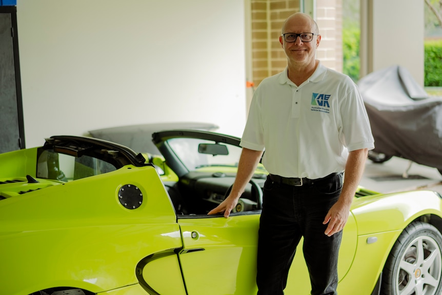 Michael next to electric green Lotus car in garage