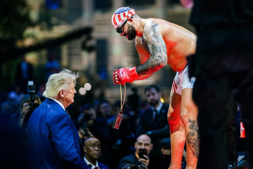Josh Hokit puts a necklace on US president Donald Trump after a UFC fight at the White House.