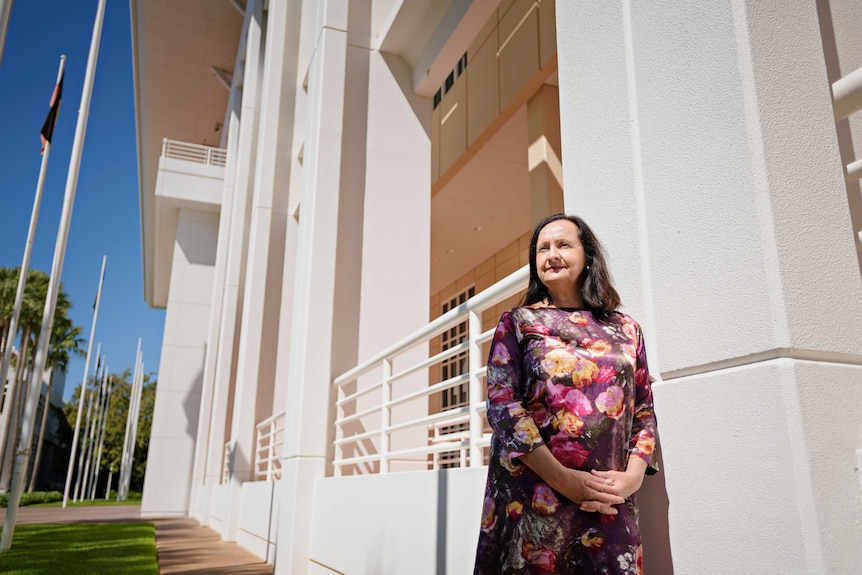 A photo of NT politicians Robyn Lambley leaning against a column of NT Parliament and looking into the distance.