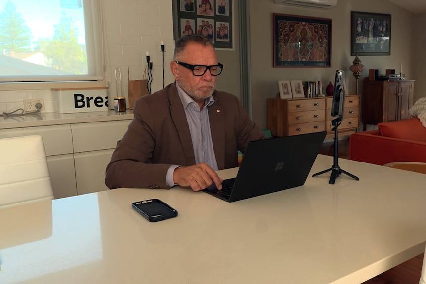 sean gordon CEO of Indigenous consultancy firm Gidgee Group sits at a desk behind a lap top working