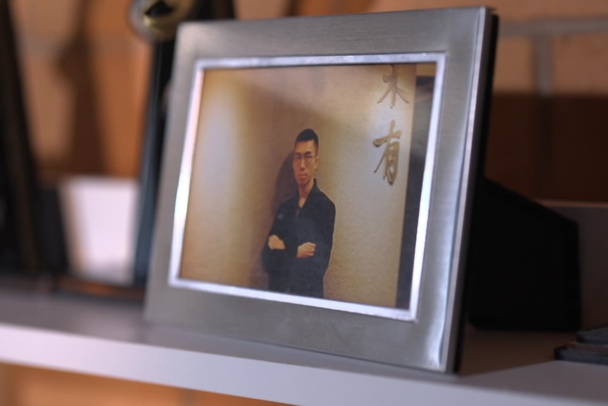 A framed photo of Justin on his bookshelf