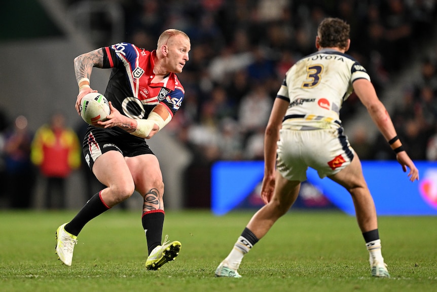 A man runs the ball during a rugby league match