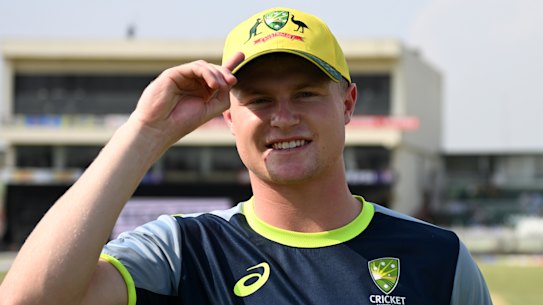 Ollie Peake tries on his new Australian cap before play.