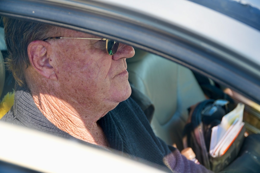 Mark Unsworth in car looks away from the camera from his car seat.