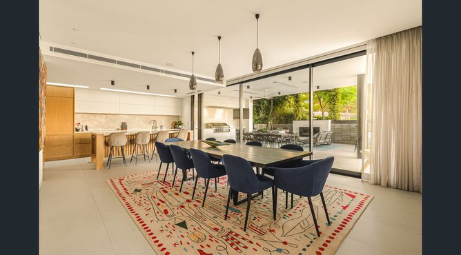 The property is a strong example of contemporary architecture that combines raw concrete finishes with warm timber accents.