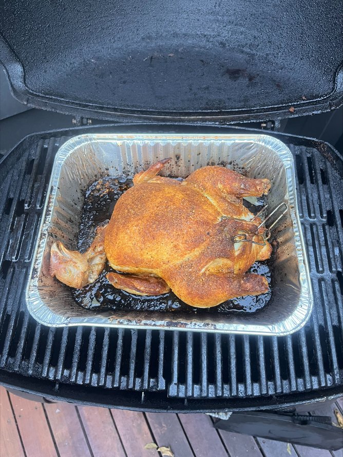 Chicken, complete with its head, seen on the barbecue. 