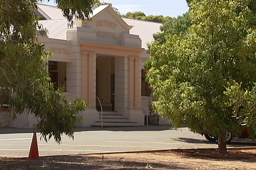 A whitewashed building with a sign say "District Hospital" above the entrance