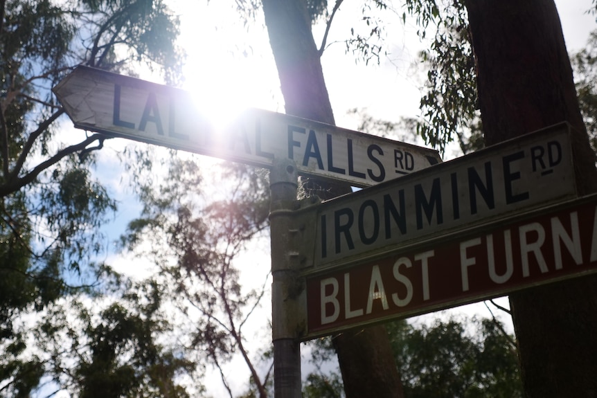 A sign that says Lal Lal falls with the sun shining through
