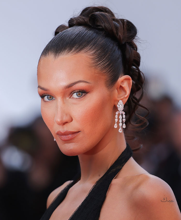 Model with sleek hairstyle and makeup highlighting facial features and bone structure Model with sleek hairstyle and makeup highlighting facial features and bone structure