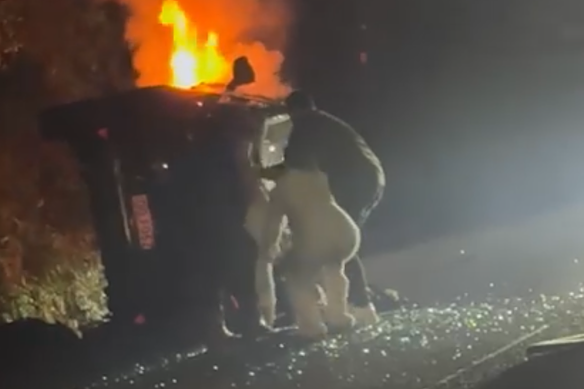 Ryles, on left in shadow, and two other members of the public help pull the woman to safety.