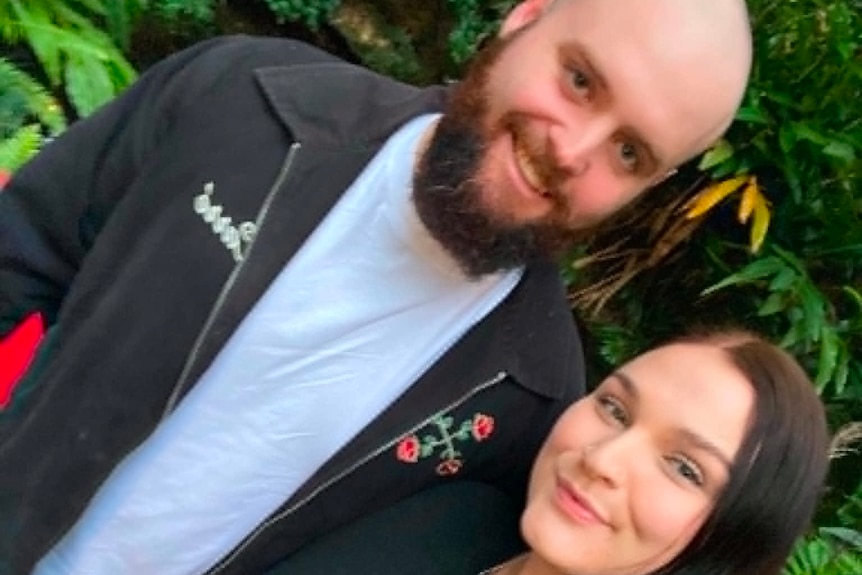 A young couple smiling at the camera