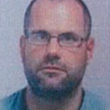 A man with glasses without an expression on his face.