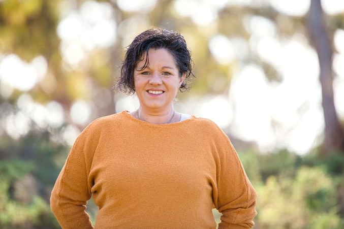 A woman standing in bushland.