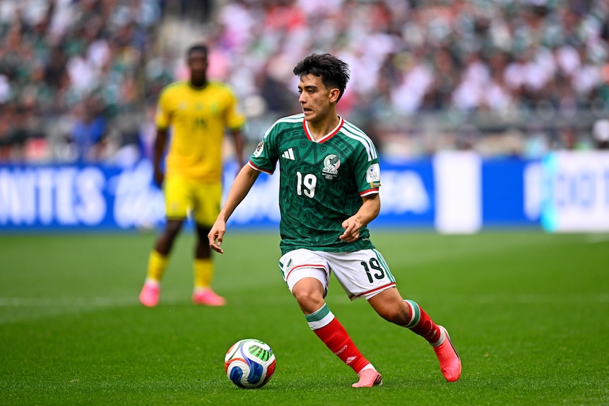 Mexico's Gilberto Mora dribbles with the ball against South Africa