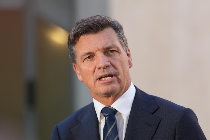A man in a suit and tie with dark-coloured hair.