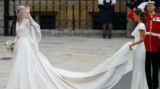 Kate Middleton in her Alexander McQueen wedding dress preparing to enter Westminster Abbey, with her sister Pippa carrying her train.