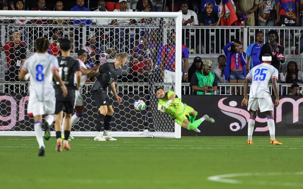 Goalkeeper Max Crocombe of New Zealand dives against Haiti