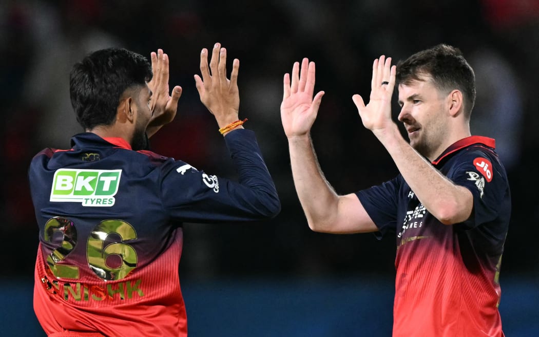 Royal Challengers Bengaluru's New Zealand cricket player Jacob Duffy (R) celebrates with teammate after the dismissal of Gujarat Titans' Indian cricket player Washington Sundar during the 2026 Indian Premier League (IPL) T20 match between Royal Challengers Bengaluru and Gujarat Titans at the Himachal Pradesh Cricket Association (HPCA) Stadium in Dharamshala on May 26, 2026. (Photo by TAUSEEF MUSTAFA / AFP) / -- IMAGE RESTRICTED TO EDITORIAL USE - STRICTLY NO COMMERCIAL USE --