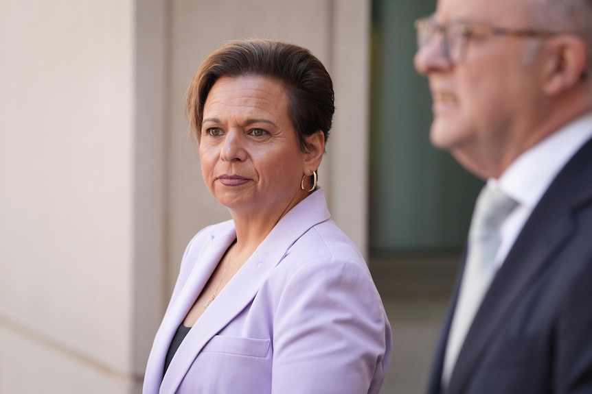 Rowland stands in the prime minister's courtyard smiling.