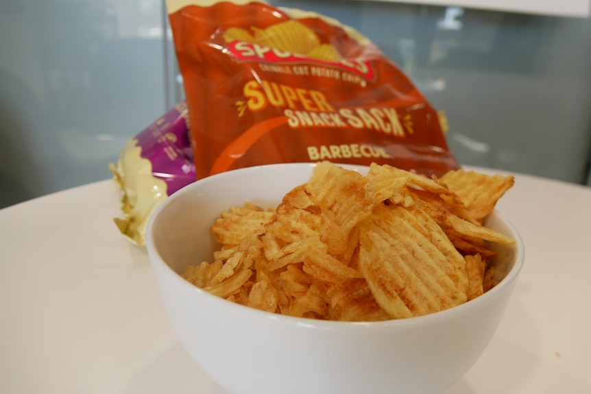 A bowl of spuddies chips in front of two packets.