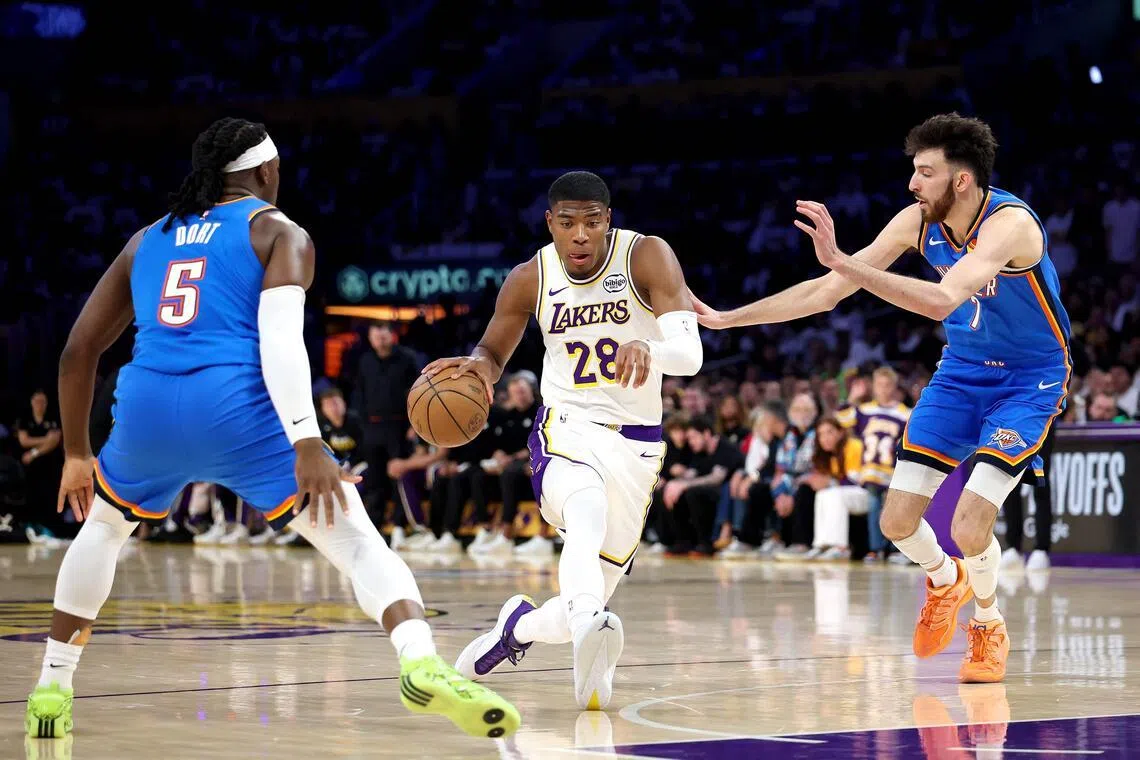 Los Angeles Lakers forward Rui Hachimura (in white) drives to the basket against Oklahoma City Thunder's Luguentz Dort (No. 5) and Chet Holmgren (No. 7) in Game Three of their NBA Western Conference Playoffs semi-finals series in May 9.