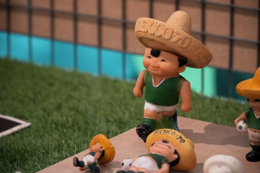 A small figurine of a footballer wearing a sombrero with the words 'Mexico 70'