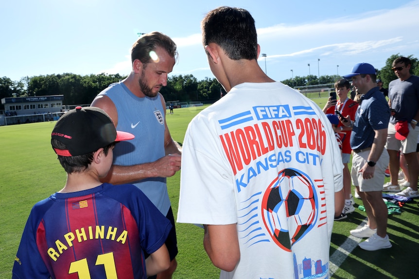 Harry Kane signs autgraphs for fans at an England training session