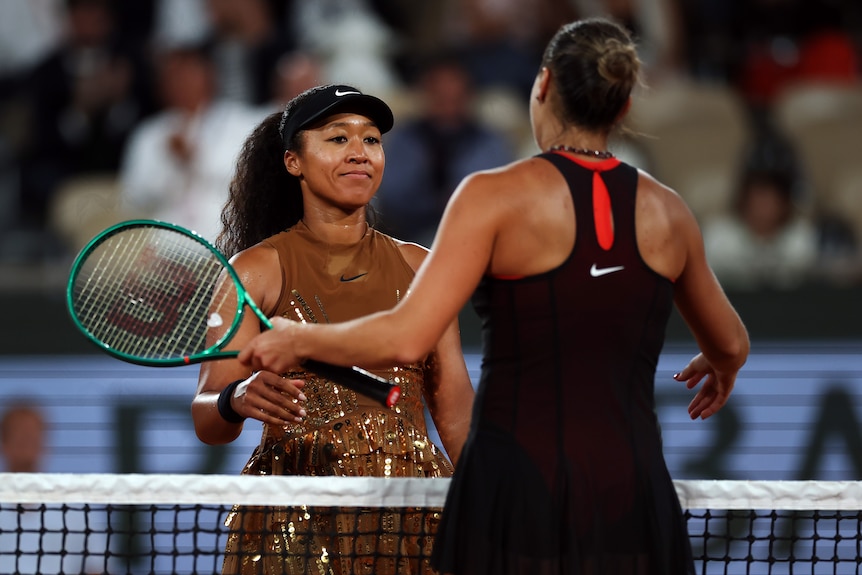 Naomi Osaka hugs Aryna Sabalenka at the net after their French Open match.