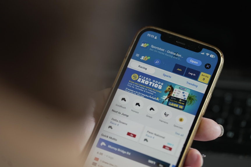 Close up of the Sports Bet app on a mobile phone in a woman's hand.