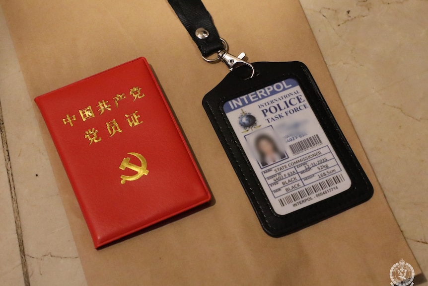 A red document with a Chinese letters and a hammer and sickle and a fake police badge.